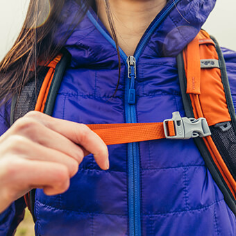 Perforated shoulder harness with sternum strap featuring integrated safety whistle