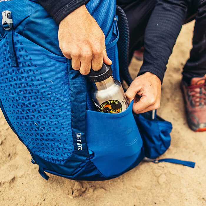 2 tasche laterali elasticizzate con doppio accesso, comode mentre si è in movimento (nei modelli 55L-65L / 53-63L)